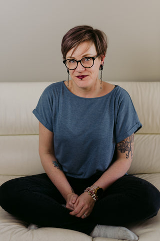Femme assise qui porte un t-shirt bleu.