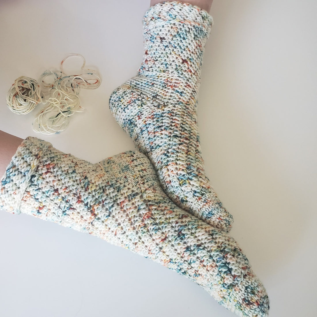 A family story crochet socks on turquoise background.
