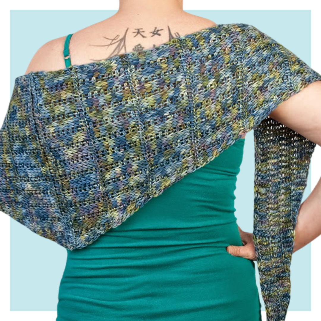 Adstock Tunisian Crochet Shawl Pattern worn by woman with her back turned against a turquoise background.