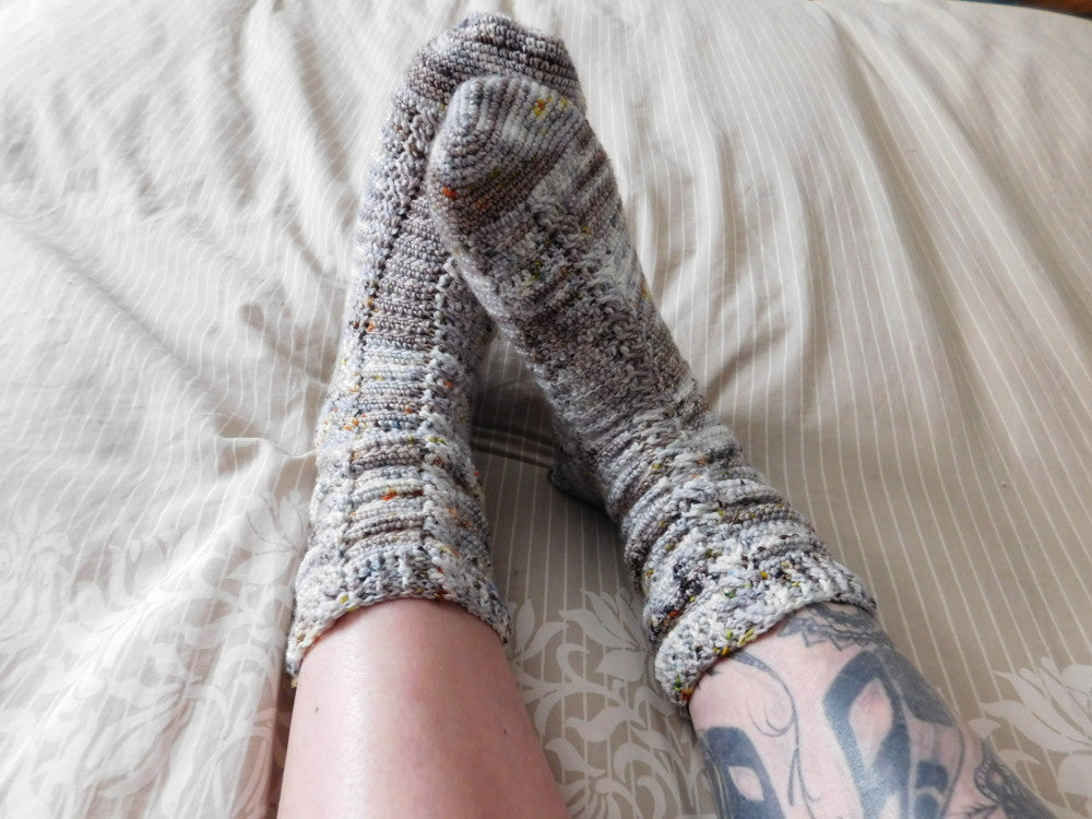 Almost the same crochet socks on turquoise background.