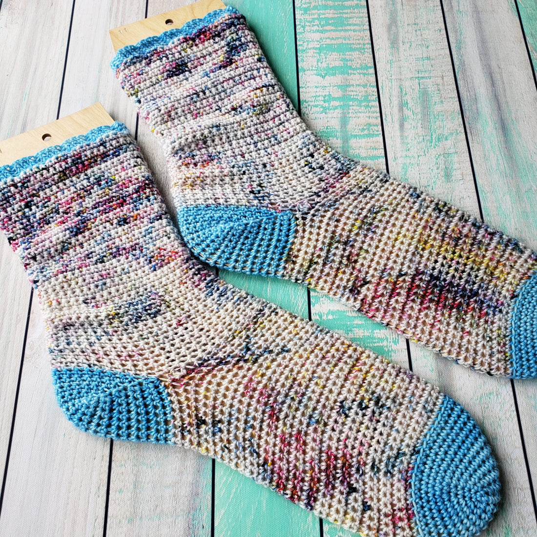 Bahzeek crochet socks on turquoise background.
