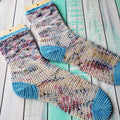 Bahzeek crochet socks on turquoise wood background.