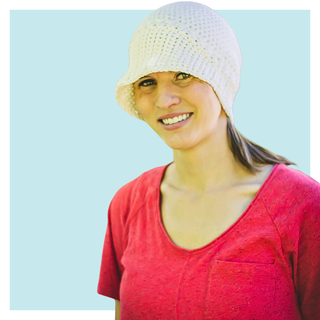 Bella Sun Hat worn by young woman on turquoise background.