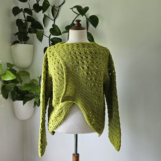 Blueberry Jam Crochet Sweater on mannequin with plants in the background.