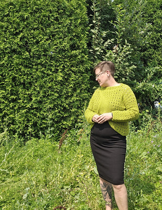 Blueberry Jam Crochet Sweater worn by woman in a black dress outside in summer.