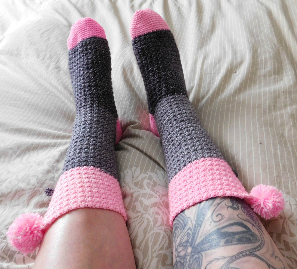 Confiture crochet socks on beige bedspread.