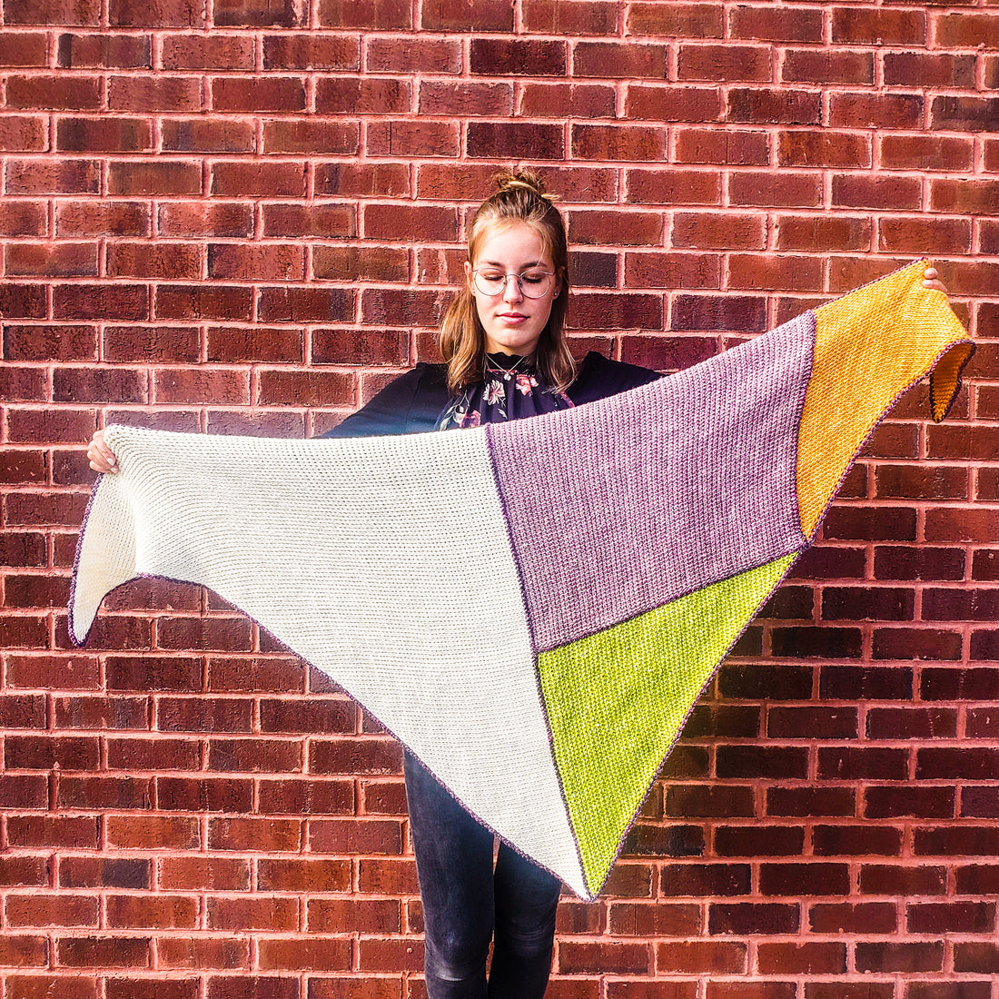 Cubic Tunisian Crochet Shawl held by teenager in front of brick wall.