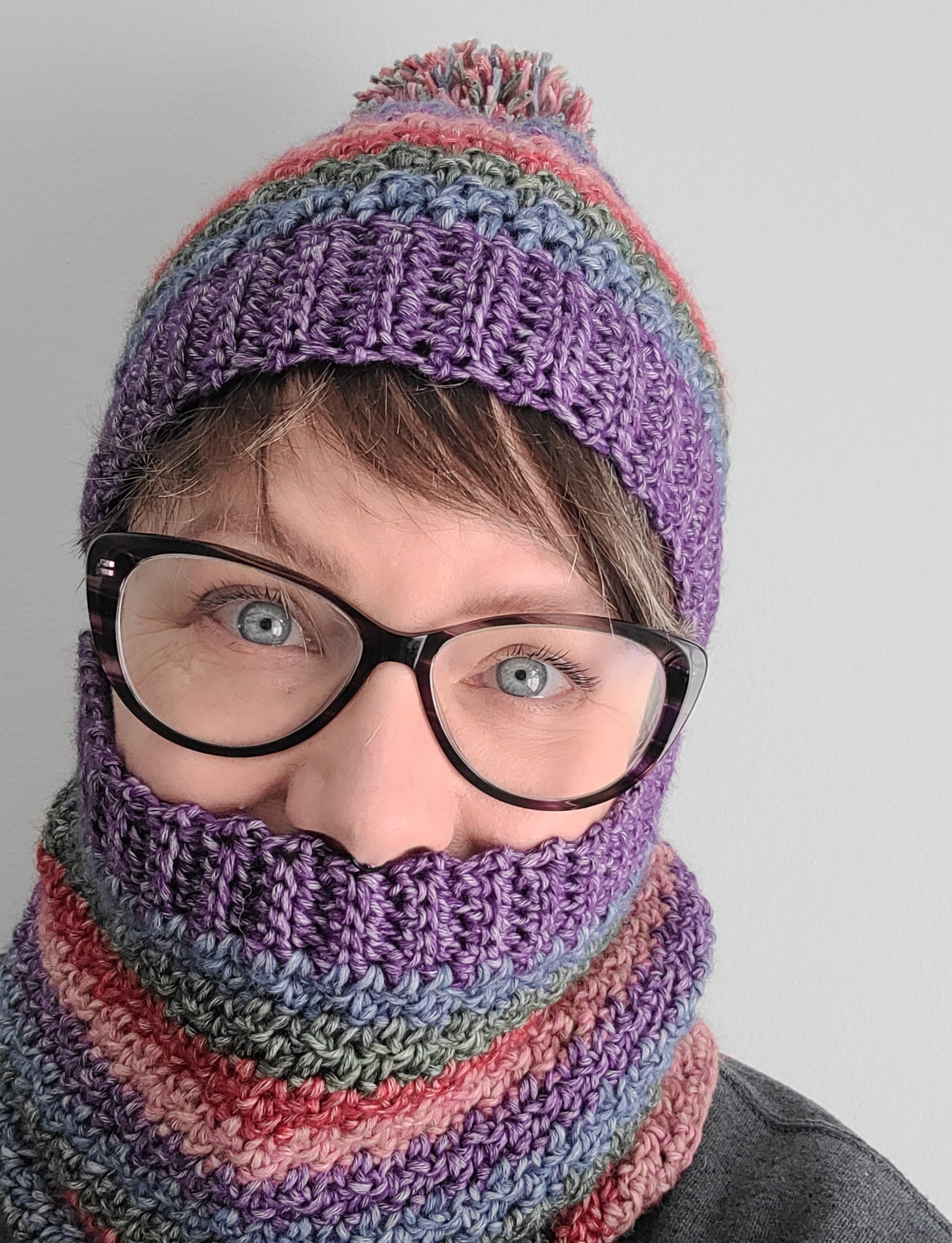Da Boss Crochet Hat and Cowl worn by woman wearing glasses on white background.