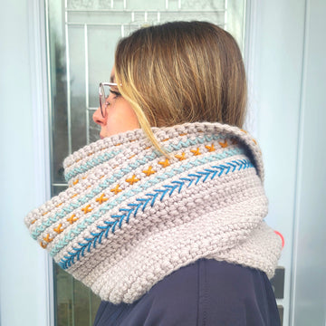 Embroidered crochet scarf worn outside by young woman, viewed from the side.