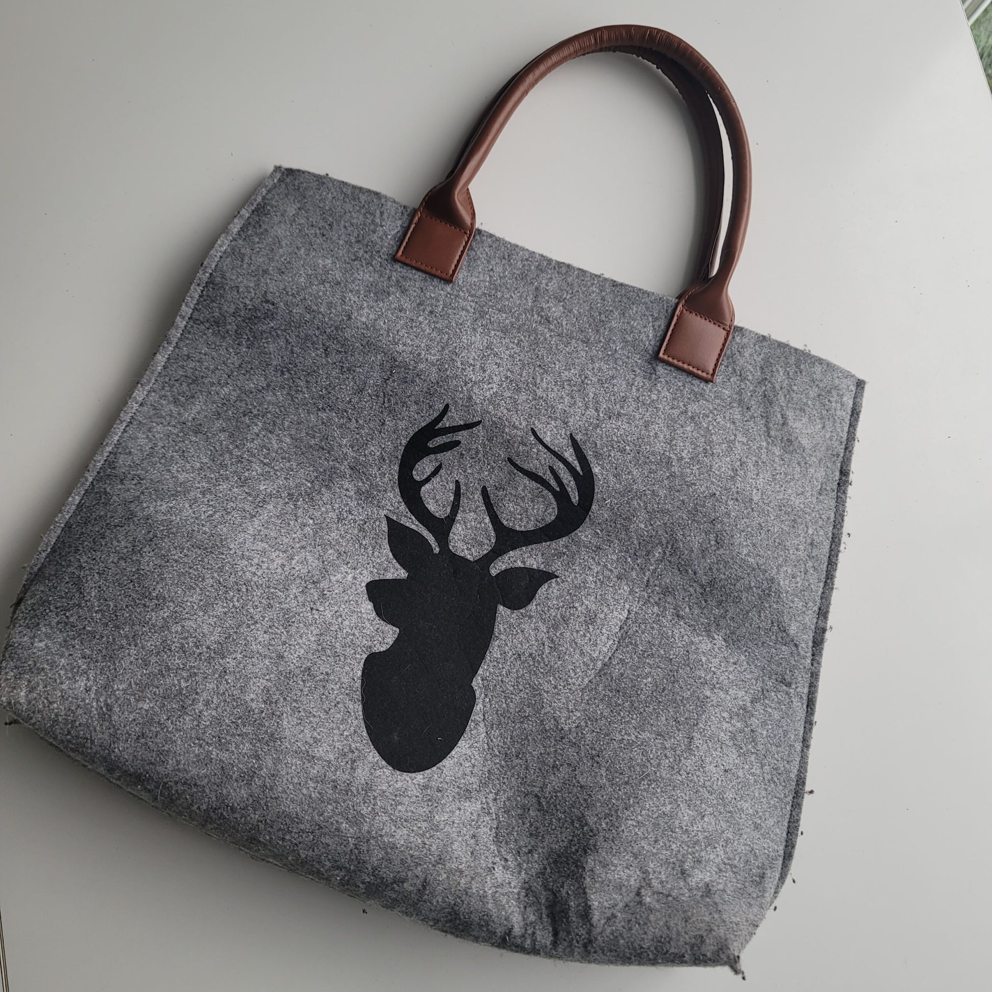 Felted tote bag with deer silhouette.
