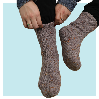 Fireside crochet socks on turquoise background.
