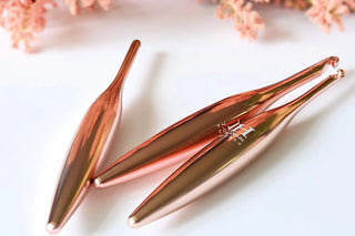 Furls Crochet Hooks Blush Metal  on white background with pink flowers.