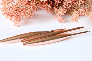 Furls Crochet Hooks Blush Metal  on white background with pink flowers.