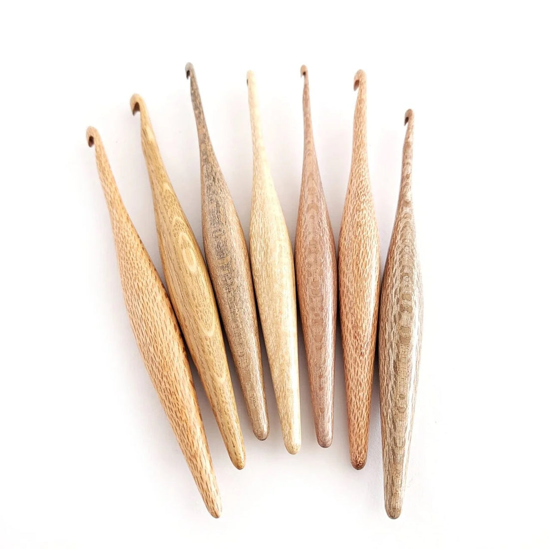 Furls Silver Oak Hooks held against off white background.