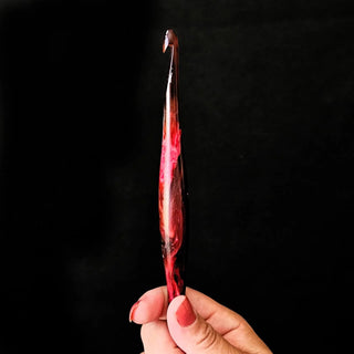 Furls Streamline Hooks Aries in hand on black background.