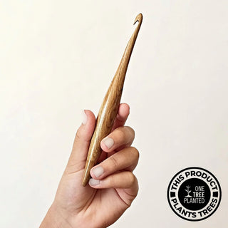 Furls Streamline Wood Teak Hook held against white background.