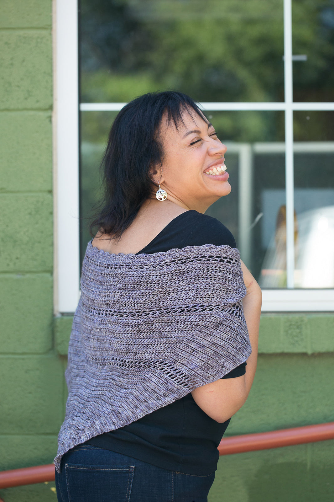 Inverse Crochet Shawl worn by smiling woman outside.