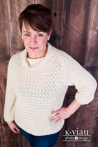 Beige Jacqueline Crochet Pullover worn by woman against dark background.