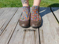 Joséphine crochet socks worn in brown shoes on a patio.