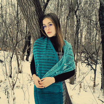 Juniper crochet shawl worn by young woman in a forest in winter.