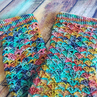 Colourful crochet socks on wood background.