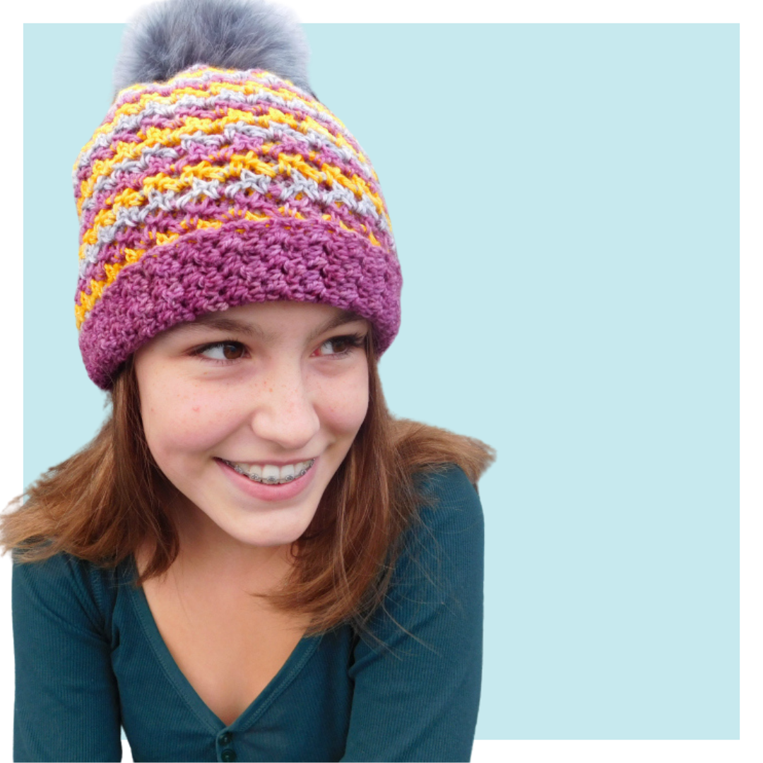 Milki crochet hat worn by teen on turquoise background.