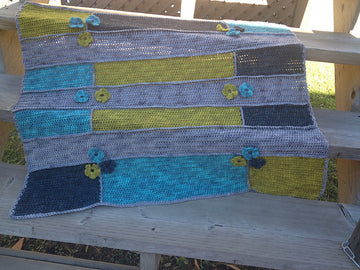 Modern Hippie Crochet Blanket laying on deck stairs.