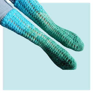 Ocean view crochet socks on turquoise background.