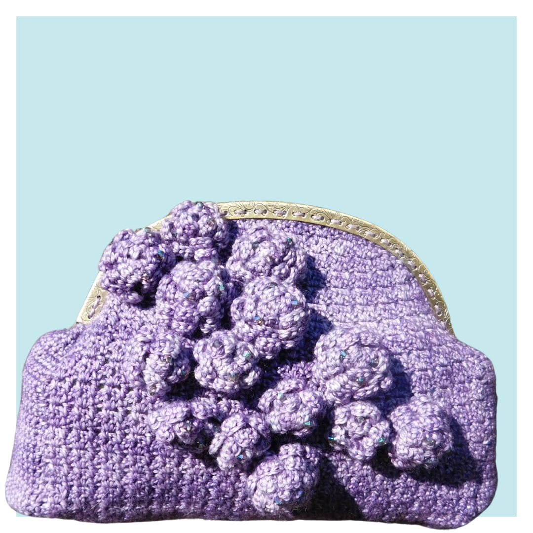 Purple origami clutch on turquoise background.