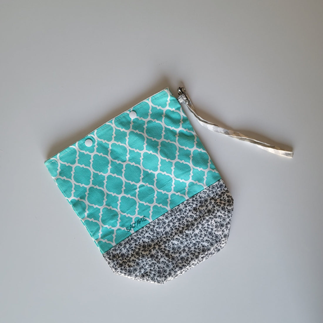 Project bag with turquoise and white, and gray and white patterned fabric.