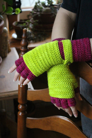Picture of the purple and yellow puppeteer crochet gloves worn by person leaning on a chair.