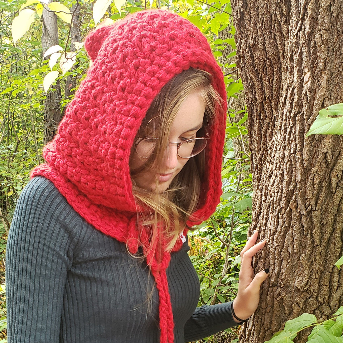 Red-Riding-Hood-Crochet worn by young woman leaning against a tree.