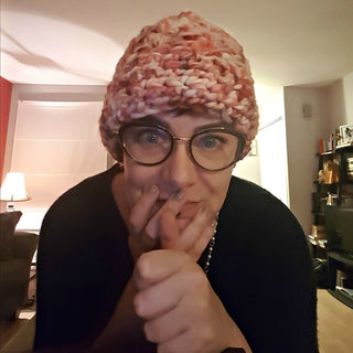 Pink Shelly 3 hour crochet worn by woman wearing glasses in a living room.