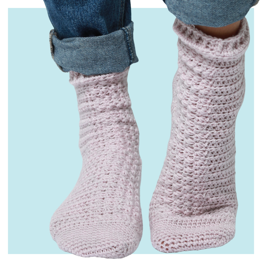 Shooting stars crochet socks on turquoise background.