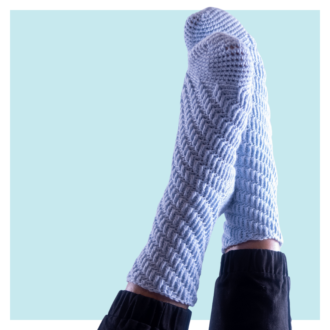 Skyscraper crochet socks on turquoise background.