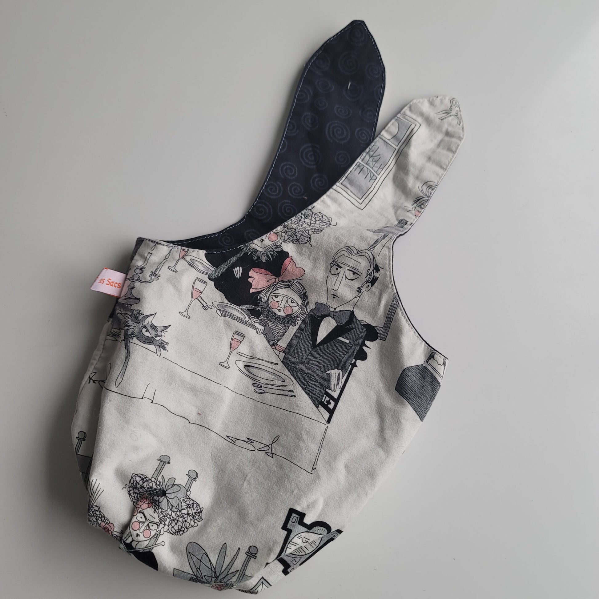 Small project bag with gray and pink creepy cartoon family print.