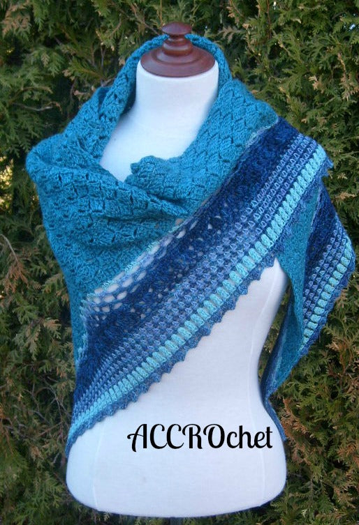 Summer Rain Crochet shawl on mannequin in front of foliage.