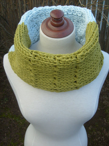 Green and light blue Summer Tunisian Crochet Cowl on mannequin outside.