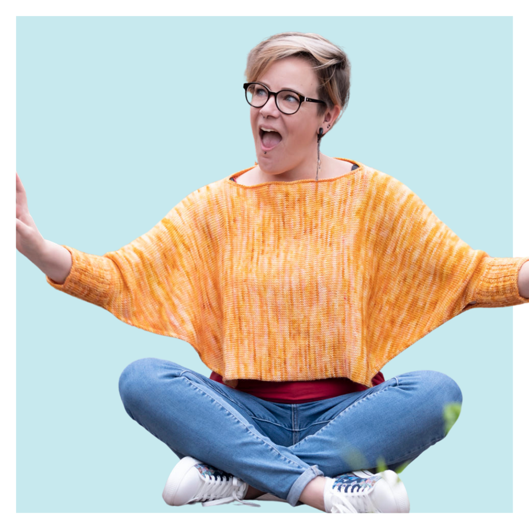 Sunset Boulevard Tunisian Crochet Pattern worn by woman sitting cross-legged against Turquoise background.