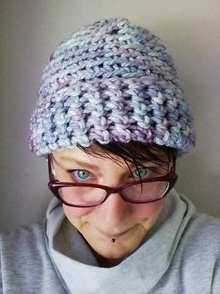 Blue Swiftyloo Crochet Hat worn by woman wearing glasses.