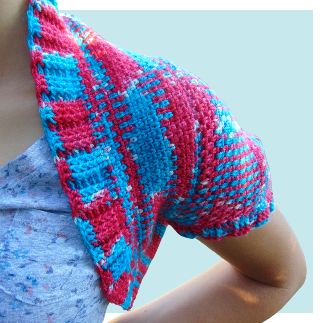 The rocket crochet shrug on turquoise background.