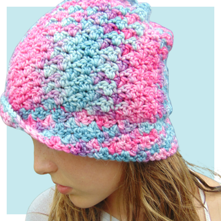 Unicorn convertible cowl worn by teen as a hat on turquoise background.