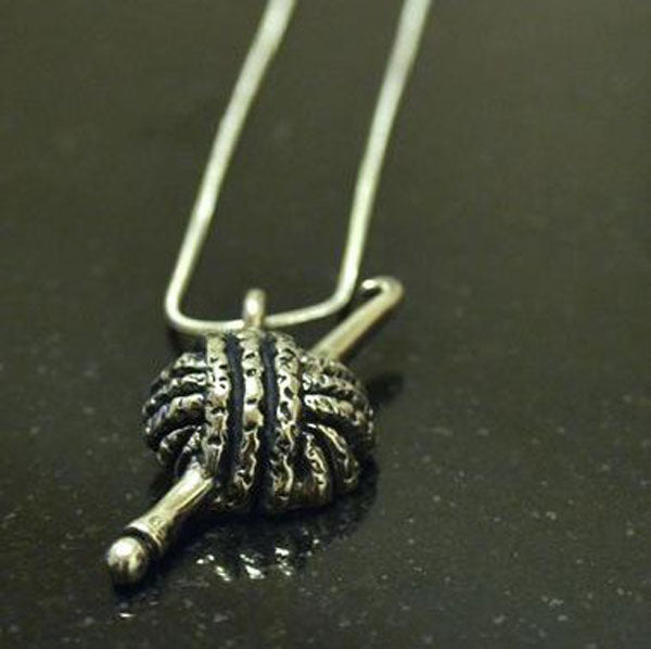 Yarn and hook pewter pendant.