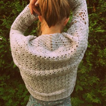 Young woman with back turned wearing crochet shrug