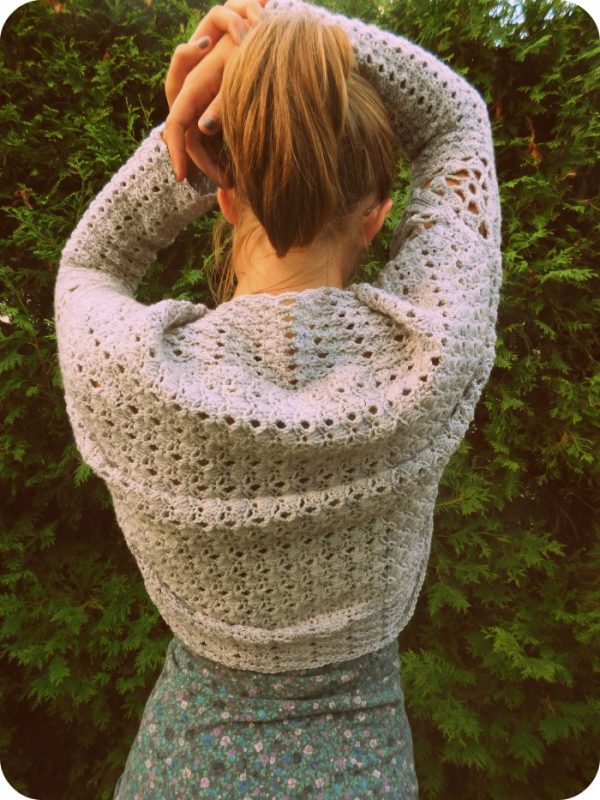 Young woman with back turned wearing crochet shrug