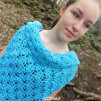 Young woman in the woods wearing blue crochet top