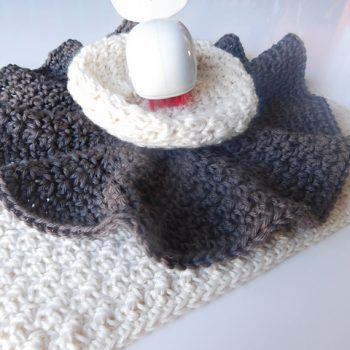 Crochet washcloths with white plastic whale on top.