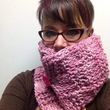 Woman with short hair wearing pink crochet cowl