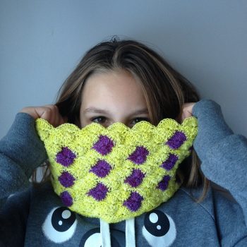 Young girl showing off yellow and purple crochet cowl