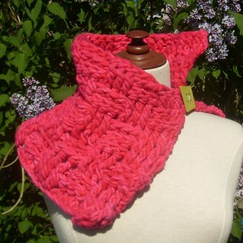 Hot pink crochet cowl on mannequin in front of lilac tree